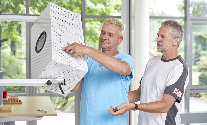 Ein Patient der Knappschafts-Klinik Warmbad schraubt etwas fest in einer stehenden Position. Ein Patient der Knappschafts-Klinik Warmbad schraubt etwas fest in einer stehenden Position.